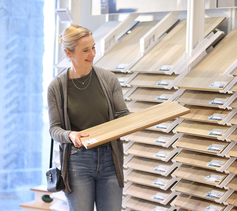 Women holding flooring sample in floor store